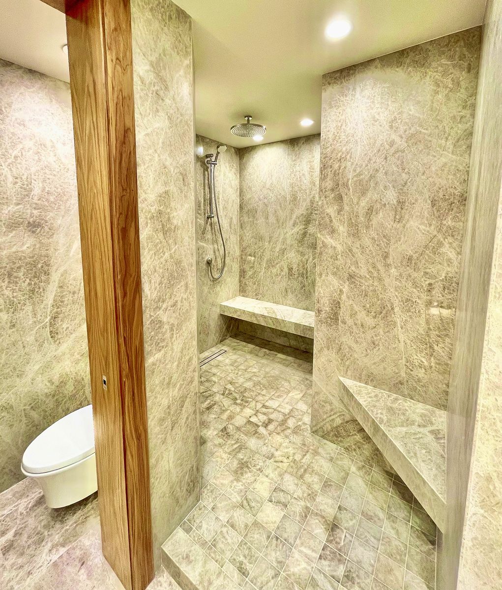 Walk-in stone shower with bench